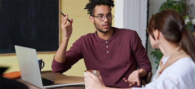 two people with a laptop discussing accessible web design